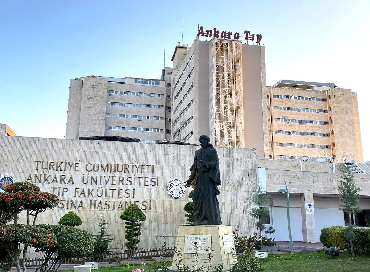 Ankara Üniversitesi Tıp Fakültesi İbni Sina Hastanesi binası ve önünde heykel.